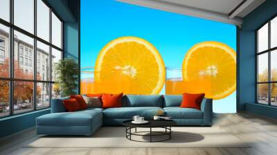 Two glasses of orange juice on the beach Wall mural