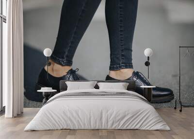 Legs of a female wearing fashionable black loafers Wall mural