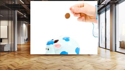 hand is putting money into piggy bank, isolated on white backgro Wall mural