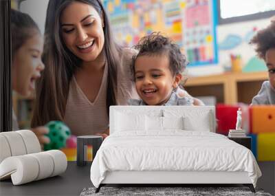 smiling teacher and happy preschool children playing together with colorful toys at kindergarten Wall mural