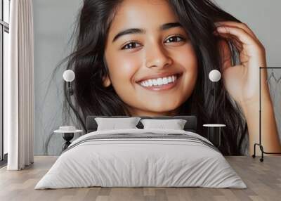 Beautiful Modern Indian Girl in Plain Top Touching Her Luscious Hair Against Plain Background generative ai Wall mural