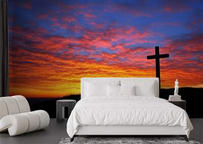 A cross silhouetted against a vibrant sunrise on the horizon  Wall mural