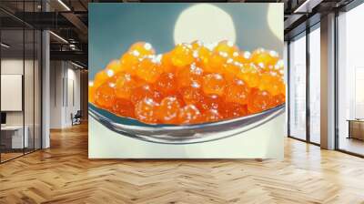 A close-up of a spoonful of vibrant orange fish roe, showcasing its glossy texture and round shape against a blurred background. Wall mural