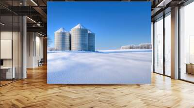 A serene winter landscape featuring two silos surrounded by snow, highlighting rural agriculture in a tranquil setting. Wall mural