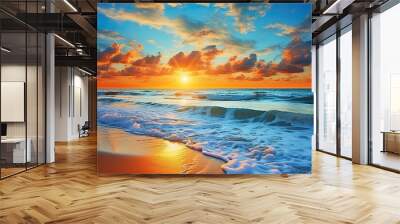 A sunset over the ocean with waves crashing on the shore and rocks. Seascape with sand beach, cloudy sky. Wall mural