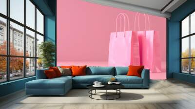 two pink shopping bags on a light pink background Wall mural