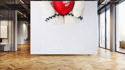 Close up of little girls hands holding red heart with copy space Wall mural