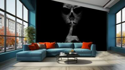 evil man gesturing silence, quiet isolated on black background Wall mural