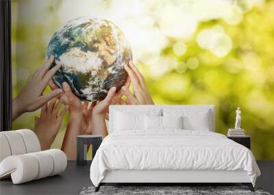 Group of children holding planet earth over defocused nature background with copy space Wall mural