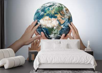 Many children hands holding planet earth isolated on blue background with copy space Wall mural