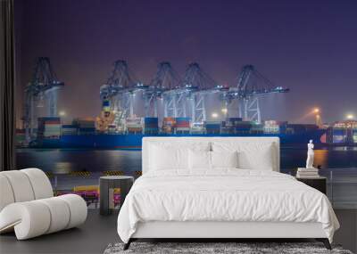 Logistics and container loading by large barges by sea in a harbor full of containers waiting to be transported Wall mural