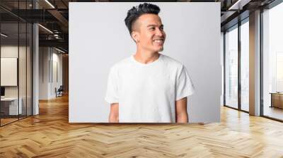 Face of happy young Asian man thinking Wall mural