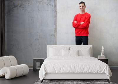 Full body shot of young handsome man with arms crossed Wall mural