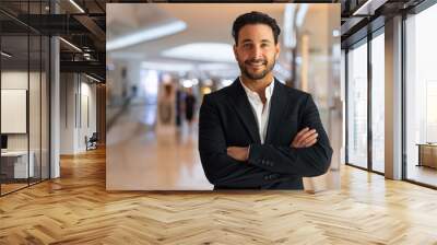 Happy Hispanic businessman smiling with arms crossed Wall mural