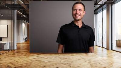 Portrait of handsome man against gray background Wall mural