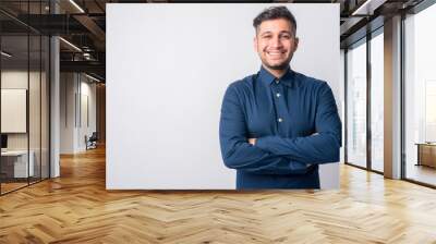 Portrait of happy young Persian businessman smiling with arms crossed Wall mural