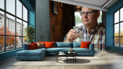 Portrait of senior businessman drinking water at the coffee shop Wall mural