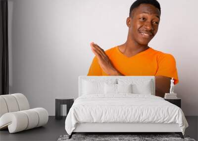 Portrait of young disgusted African man with stop gesture and looking away Wall mural