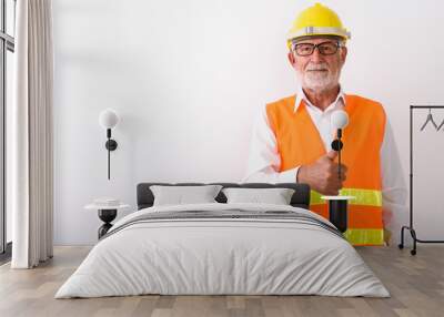 Studio shot of handsome senior bearded man construction worker g Wall mural