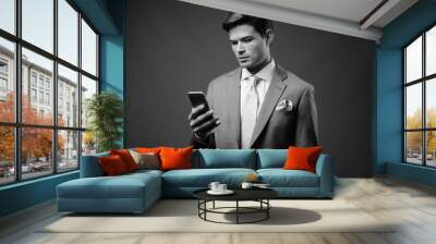 Studio shot of young handsome businessman in suit Wall mural