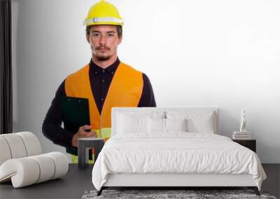 Studio shot of young handsome man construction worker holding cl Wall mural