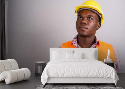 Young African man construction worker against white background Wall mural