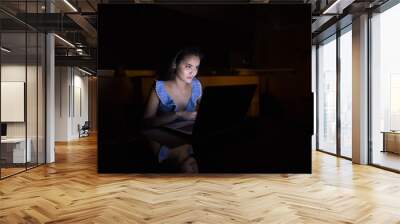 young asian woman using laptop in dark room Wall mural