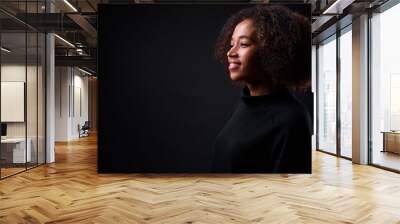 Young beautiful African woman with Afro hair against black background Wall mural