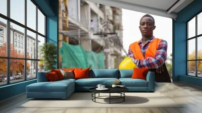 Young black African man construction worker holding clipboard an Wall mural