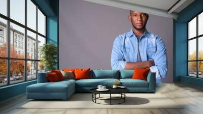 Young handsome African man with short hair against gray backgrou Wall mural