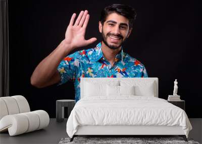 Young handsome bearded Persian tourist man ready for vacation against black background Wall mural