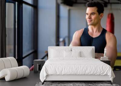 Young handsome man thinking with arms crossed at the gym Wall mural