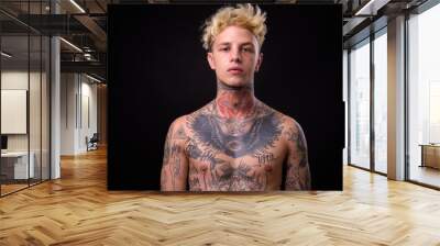 Young handsome rebellious man with tattoos shirtless Wall mural