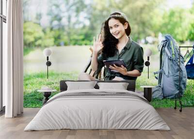 Teenage Woman travelers are sitting on tablet to shop online that involves hiking equipment. And order other items such as food, water, medicine. Summer vacations making you feel relaxed, happy Wall mural