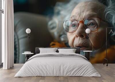 An elderly woman in glasses and an oxygen mask sits in a chair Wall mural