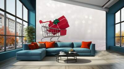 Shopping cart with christmas gift on snow and sparkle bokeh background with copy space Wall mural