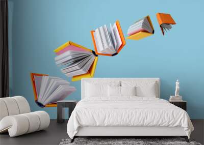 books in colored covers swirl on a blue background, copy space Wall mural