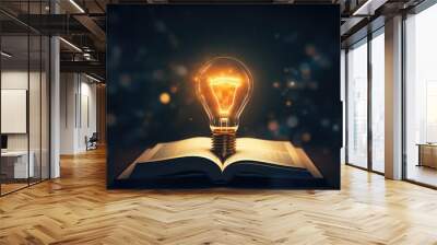 Open book with glowing light bulb on dark background Wall mural