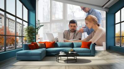 team of three coworkers in stylish studio Wall mural