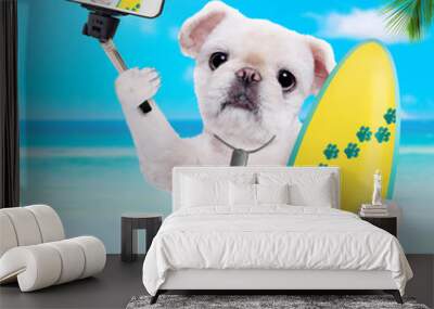 Beautiful surfer dog on the beach taking a selfie together with a smartphone.  Wall mural