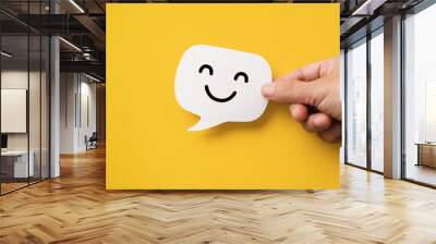 Hand hold happy face on real speech bubbles to each other. Giving good words to each other or giving positive feedback satisfaction from good customer feedback reviews Wall mural