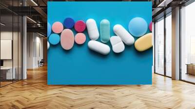 Different pharmaceutical colorful medicine pills, tablets and capsules on bright blue background. Medicine creative concepts. Flat lay top view with copy space Wall mural