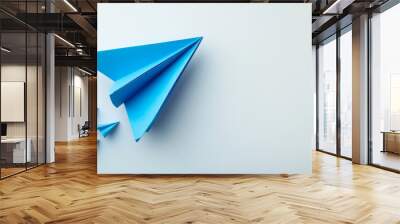 blue paper plane symbolizes creativity and innovation, soaring above smaller paper planes on light background, representing business strategy and forward thinking Wall mural