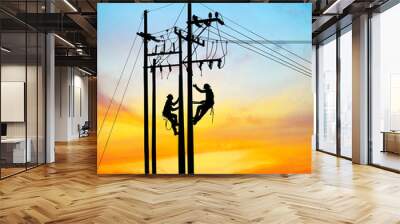 Silhouette Electrical engineers working on electricity pylon high tension power line repairs and maintenance  on blurry sunset background Wall mural