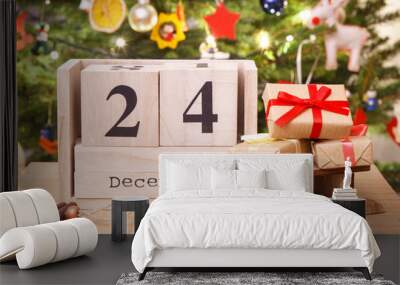 Date 24 December on calendar, wrapped gifts and christmas tree with decoration, Christmas eve time concept Wall mural