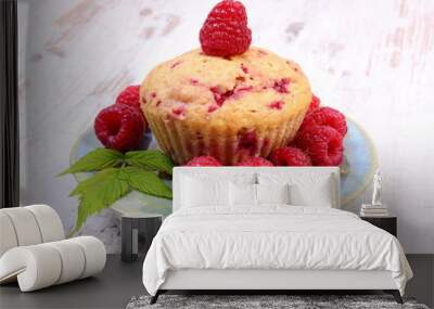 Fresh baked cupcake and raspberries on plate on old wooden background, delicious dessert Wall mural