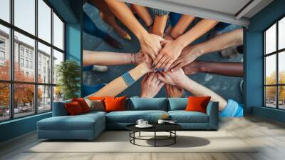 A top view of a group of friends stacking their hands together, Community of people stacking hands together - Multiracial people putting their hands on top of each other  Wall mural