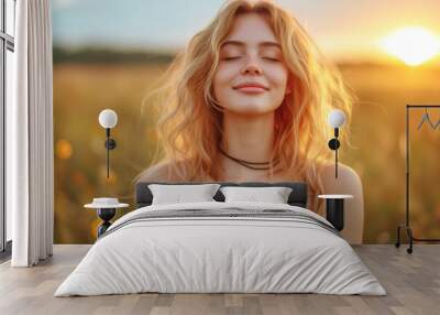 Calm happy smiling woman with closed eyes enjoys a beautiful moment life on the fields at sunset. Wall mural