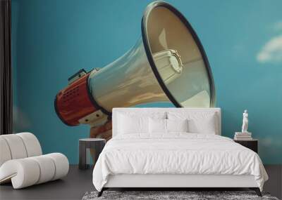 Hand holds white and red megaphone against the blue sky.  Wall mural