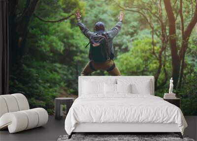 Happy backpacker man jumping on the top of the mountain, successful fun happy man. Wall mural